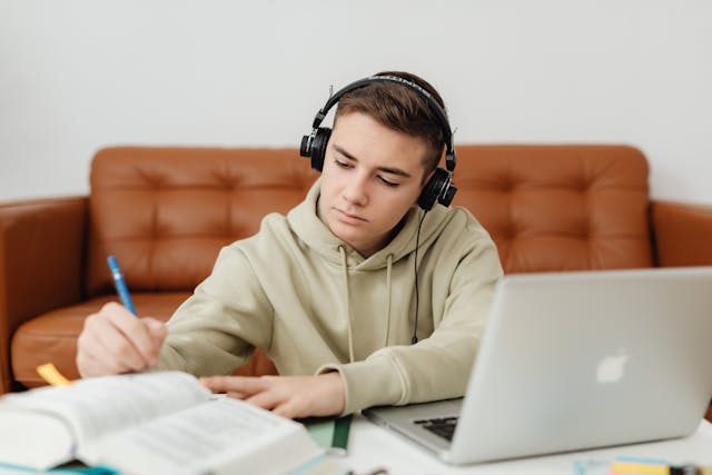 homework success:  teenager wearing earphones with a computer